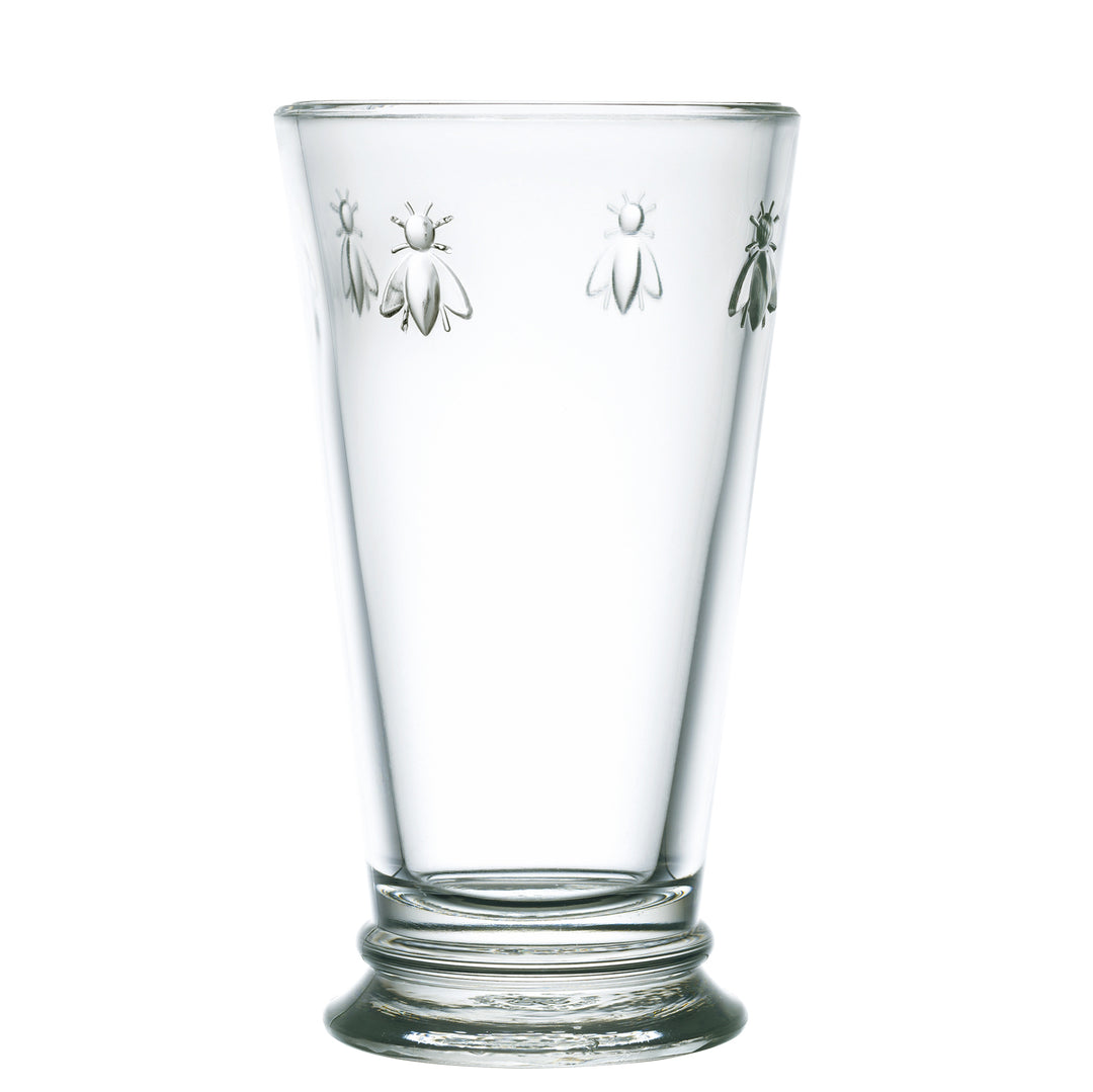 A clear highball glass with napoleonic bee engravings on it.